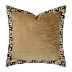 a gold and black pillow on a white background with an intricate border in the middle