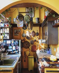 a kitchen with pots and pans hanging on the wall above the stove top oven