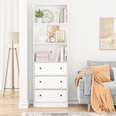 a living room with a gray couch and white bookcase next to a painting on the wall