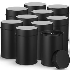 several black and white containers with lids on the top one has a ring in it's center