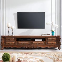 a living room scene with focus on the entertainment center and flat screen tv above it