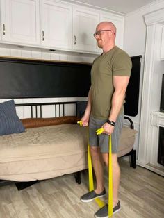 a man standing in front of a bed holding two yellow handles