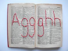 an open book with the word agoph written in red thread on top of it