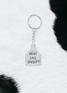 a keychain that says drive safe cowboy on it's front and back