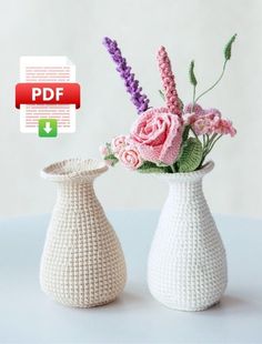 two crocheted vases with pink and purple flowers in them on a table