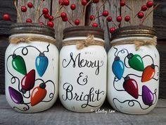 three painted mason jars sitting next to each other