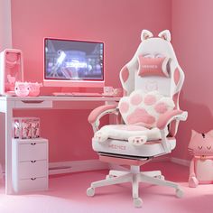 a pink and white desk with a computer monitor, cat pillow, and chair in front of it