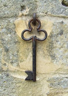 an old iron key attached to a stone wall