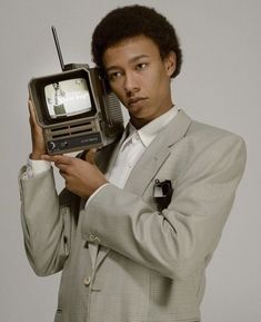 a man in a suit holding an old fashioned radio