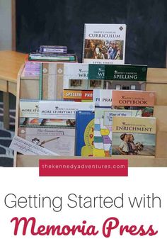 a pile of books sitting on top of a wooden table next to a chalkboard