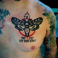 a man with tattoos on his chest has a bee tattoo on it's chest