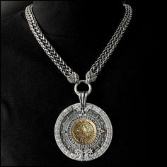 "This piece features my huge 3\" (76mm) antique silver finish Aztec Calendar Stone design medallion with an antique bronze centerpiece on a double-strand antique braided chain with eagle wings ends. It will catch every eye within 50 feet and be the source of many conversations. The look and feel of our necklace upon the first touch will speak to you immediately of hand-crafted quality. It makes a stunning accessory - appropriate for all ages, men or women - all will love it. It includes a black Silver Medallion Necklace With Chain, Engraved Metal Medallion Coin Necklace, Antique Silver Medallion Necklace With Coin Pendant, Silver Brass Amulet Coin Necklace, Silver Coin-shaped Medallion Necklace In Brass, Luxury Silver Medallion Necklace, Luxury Silver Engraved Medallion Necklace, Luxury Engraved Silver Medallion Necklace, Antique Silver Medallion Coin Necklace