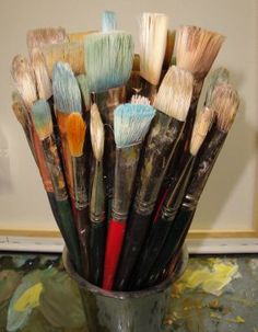 a cup filled with lots of paint brushes