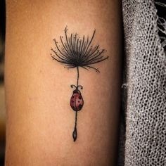 a ladybug tattoo on the arm