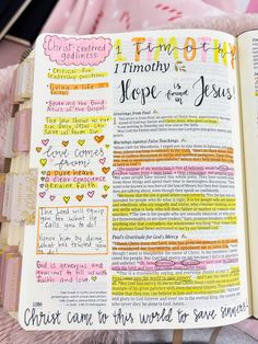 an open bible with colorful writing on the pages and some other things in it that are handwritten