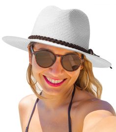 a woman wearing a hat and sunglasses taking a selfie