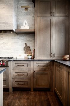 a kitchen with wooden cabinets and marble counter tops