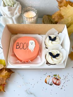 an open box with cupcakes decorated like ghostes and the word boo on it