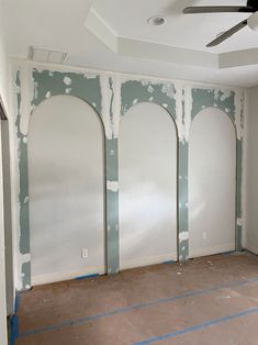 an empty room with white walls and blue tape on the floor in preparation for painting