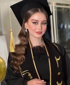 a woman wearing a graduation gown and holding a cell phone