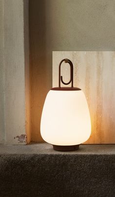 a lamp sitting on top of a step in front of a wall next to a door