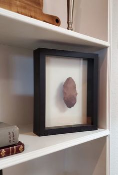 a shelf with some books and an object on it