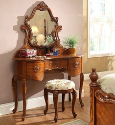 a bedroom with a vanity, mirror and stool