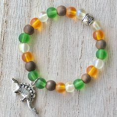 This kids bracelet features a silver plated metal Stegosaurus charm framed by glass and silver plated metal beads strung on 0.88 mm clear stretch cord. It is 5.625'' in length with a 1.5'' diameter and would best fit a 4-6 year-old. Nickel and Lead Free. ------------------------------ I use high-quality 0.88 mm pre-stretched stretch cord. My knots are triple-tied and finished with a dab of adhesive to ensure security. ------------------------------ All of my jewelry pieces come in a stylish draw Adjustable Silver Themed Beaded Bracelets, Adjustable Novelty Stretch Bracelet With Colorful Beads, Dino Bracelet, Adjustable Hand-strung Stretch Bracelet For Beach, Dinosaur Bracelets, Hand-strung Green Agate Stretch Bracelet, Kids Bracelet, 3d Perler Bead, Aluminum Jewelry