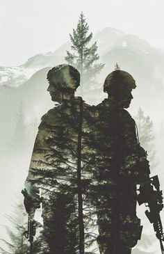 two soldiers standing next to each other in front of trees and mountains with snow on the ground