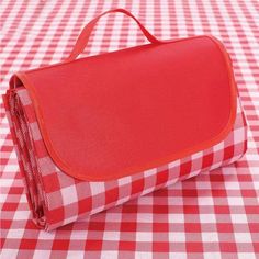 a red and white checkered table cloth with a bag on it's side