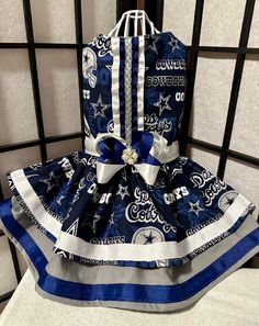 a dress made to look like it is sitting on top of a bed with blue and white fabric