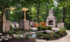 an outdoor fireplace surrounded by landscaping and trees