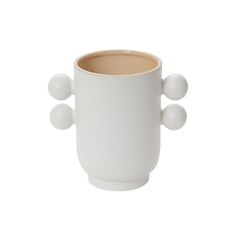 a white coffee cup with three balls on the top and one ball at the bottom