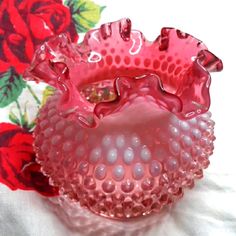 a pink glass vase sitting on top of a table