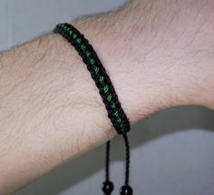 Black braided bracelet with a green line, this bracelet is adjustable to fit wrist sizes from 6 to 9 inches, with an easy to use zip like function to fit your wrist, you'll have it on as soon as you get it. Made from high quality string, it will be sure to last. Each bracelet is carefully handcrafted and give proper time to ensure quality. Fast and Free shipping Adjustable Casual Wristband Bracelet, Black Braided Casual Friendship Bracelets, Casual Resizable Wristband As Gift, Handmade Black Nylon Cord Bracelets, Green Adjustable Friendship Bracelets As Gift, Adjustable Green Friendship Bracelets As Gift, Casual Braided Beaded Bracelets As Gift, Casual Braided Beaded Bracelets For Gift, Green Beaded Bracelets With Adjustable Length