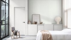 a bedroom with white walls and furniture in it