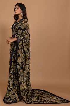 Editor's Note Featuring Varun Bahl's statement floral printed sari highlighted with intricate hand embroidery all over. It is paired with an embroidered black blouse. Fabric: Organza Color: Black Component: Sari, blouse and underskirt Sleeve type: Sleeveless Neckline: V neck Fit: Fitted blouse Embroidery details: Hand embroidery Occasion: Wedding, Festive Blouse length: 14" inches, saree: 5.5 metres, sari width: 45" inches Care: Dry Clean Only About the Designer Varun’s work marries the beauty o Varun Bahl, Cutdana Embroidery, Marriage Dress, Bridesmaid Saree, Floral Saree, Indian Dresses Traditional, Black Saree, Dress Indian Style, Organza Saree