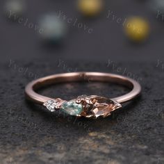 a rose gold ring with two pear shaped morganite and diamond accents on the side