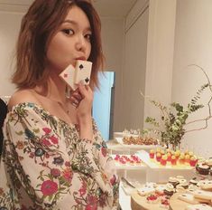 a woman standing in front of a table filled with desserts