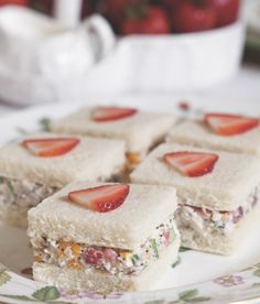 several sandwiches with strawberries on them sitting on a plate