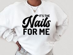 a woman wearing a white sweatshirt that says it's the nails for me