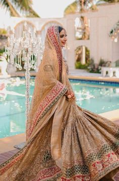 a woman in a bridal gown standing next to a pool