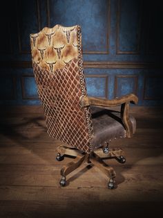 an old chair with a snake skin back and foot rests on a wooden floor in front of a blue wall