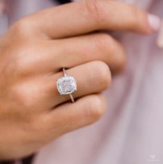 a close up of a person wearing a ring with a diamond on it's finger