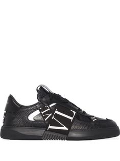 VL7N low-top sneakers from VALENTINO GARAVANI featuring black, leather, round toe, logo-print strap, logo patch at the tongue, branded heel counter, perforated toebox, front lace-up fastening and flat sole. | Valentino Garavani VL7N low-top sneakers Luxury Masculine Sneakers With Leather Sole, Luxury Black Sneakers With Leather Lining, Valentino Vlogo Shoes, Valentino Shoes Sneakers, Valentino Garavani Logo Shoes, Valentino Roman Stud Shoes, Valentino Garavani Shoes, Stylish Logo, Black Leather Sneakers