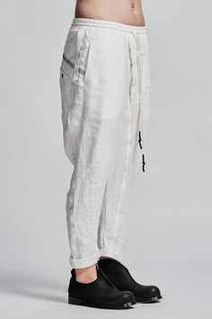 "Off-White Drop Crotch Boiled Linen Trousers with Elastic Waistband__ // EXPRESS DELIVERY ONLY __Cropped Length __Asymmetrical Hidden Front Closure __Back Black Scar Stitch __2 Front & 2 Back Pockets __Elastic Waistband with Drawstring __Fully Completed Stitching model__ bust 92 (36\"), waist 72 (28\"), hips 102 (40\"), biceps 28 (11''), height 177 (5'8\"), kg 65 (143 lbs) model wears size M | color: off-white fabric__ 100 linen care__ dry cleaning do not bleach do not tumble dry do not iron White Parachute Pants With Tapered Leg, White Parachute Pants With Tapered Legs, White Straight Parachute Pants With Side Pockets, White Baggy Linen Pants, Baggy White Linen Pants, White Tapered Leg Pants With Side Pockets, White Linen Tapered Leg Pants, Low Crotch Pants, Clothing Store Interior