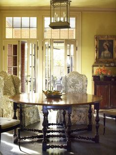 a dining room with yellow walls and chairs