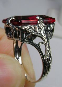 Simulated Ruby Ring GL Design#15 Made to Order This is a brand new 1930s reproduction solid sterling silver 925 floral leaf filigree approx. 10ct Simulated/man-made ruby gemstone ring. The inside of the band is hallmarked 925 for sterling. This rectangle-cut gemstone is 16mm (5/8th of an inch) by 12mm (1/2 inch) in size. Notice the beautiful leaf design of the silver filigree setting. This is an exquisite rendition of an antique filigree ring... and is ready to wear. A ring gift box is included. Red Rectangular Jewelry With Polished Finish, Red Art Deco Jewelry For Formal Occasions, Art Deco Ruby Ring For Formal Occasions, Red Emerald-cut Sterling Silver Jewelry, Formal Rectangular Ruby Ring In Sterling Silver, Rectangular Ruby Ring In Sterling Silver For Formal Occasions, Rectangular Ruby Ring In Sterling Silver For Formal Events, Red Rectangular Garnet Jewelry, Rectangular Red Garnet Jewelry