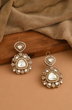 Elevate your style with our Victorian Polki Earrings, showcasing an eye-catching design with uncut polkis and gleaming cubic zirconia. This elegant pair effortlessly lights up any room, transitioning seamlessly from morning to night and providing the perfect extra sparkle to your ensemble. Finish: 22KT Gold Plating Material: Silver, Copper Alloy, Polki Color: Gold Size: One Size Closure Type: Push Back Box Contains: 1 Pair of Earrings Victorian Polki Earrings, Gold Earrings Indian Jhumkas, Polki Earrings Designer, Victorian Earrings Indian, Victorian Gold Jewelry, Polki Earrings Studs, Indian Jewelry Photography, Indian Jewellery Photography, Victorian Polki Jewellery