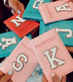 four passport holders with numbers on them are being held by two women's hands